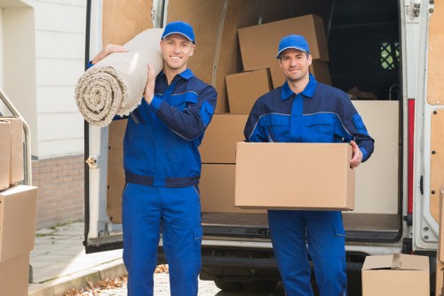 Removal team loading household items into a moving vehicle