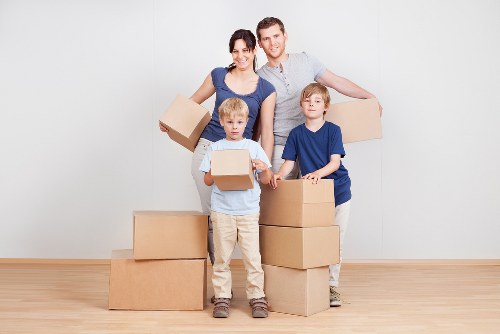 Removal team carrying boxes from a flat with stairs